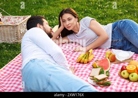 Nettes Paar, das draußen auf grünem Gras picknickt Stockfoto