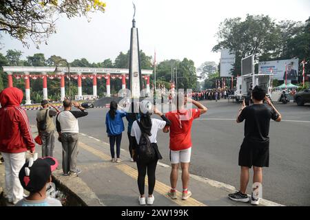 Bogor, West-Java, Indonesien. August 2024. Fußgänger machen einen Halt, um die indonesische Nationalflagge zu grüßen, um den 79. Unabhängigkeitstag Indonesiens in Bogor, West-Java, Indonesien, zu feiern. (Kreditbild: © Adriana Adie/ZUMA Press Wire) NUR REDAKTIONELLE VERWENDUNG! Nicht für kommerzielle ZWECKE! Stockfoto