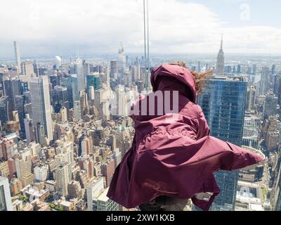 New York, USA - 2. Mai 2023: Der Wind weht gegen einen Touristen, der auf der Aussichtsplattform von 30 Hudson Yards (The Edge) in Midtown Manhat steht Stockfoto