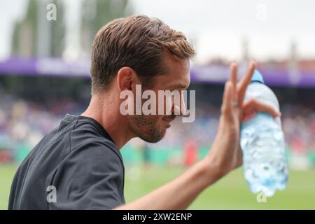 17. August 2024, Niedersachsen, Osnabrück: Fußball: DFB-Cup, VfL Osnabrück - SC Freiburg, 1. Runde im Stadion Bremer Brücke. Freiburger Trainer Julian Schuster Waves. Foto: Friso Gentsch/dpa - WICHTIGER HINWEIS: Gemäß den Vorschriften der DFL Deutschen Fußball-Liga und des DFB Deutschen Fußball-Bundes ist es verboten, im Stadion und/oder im Spiel aufgenommene Fotografien in Form von sequenziellen Bildern und/oder videoähnlichen Fotoserien zu verwenden oder zu verwenden. Stockfoto