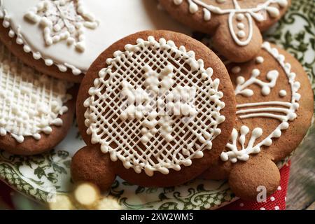 Nahaufnahme von hausgemachten Lebkuchen Weihnachtskeksen, dekoriert mit weißer Glasur auf grünem Teller Stockfoto