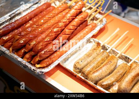 Lange und kurze Würstchen auf Spießen zum Verkauf an einem Street Food Stand. Stockfoto