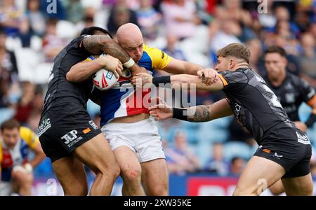 Lee Kershaw (Mitte) von London Broncos wird von Hull FC Ligi Sao (links) und Denive Balmforth (rechts) während des Spiels der Betfred Super League in Elland Road (Leeds) angegriffen. Bilddatum: Samstag, 17. August 2024. Stockfoto