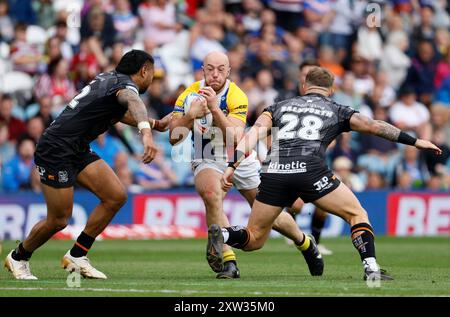 Lee Kershaw (Mitte) von London Broncos wird von Hull FC Ligi Sao (links) und Denive Balmforth (rechts) während des Spiels der Betfred Super League in Elland Road (Leeds) angegriffen. Bilddatum: Samstag, 17. August 2024. Stockfoto