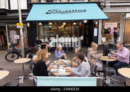 Fitzbillies Cambridge UK; Personen, die vor dem Fitzbillies Cambridge Café sitzen und essen und trinken; St Marys Passage, Cambridge City Centre, UK Stockfoto