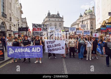 London, Großbritannien. August 2024. Tierschützer passieren den Piccadilly Circus während des National Animal Rights March im Zentrum Londons. Der jährliche Protest hebt das Leiden und den Tod von Milliarden von Tieren in allen Bereichen menschlichen Handelns hervor, kämpft für die Tierbefreiung und für ein Ende der Tierausbeutung und fördert Veganismus und einen grausamen Lebensstil. Quelle: Vuk Valcic/Alamy Live News Stockfoto