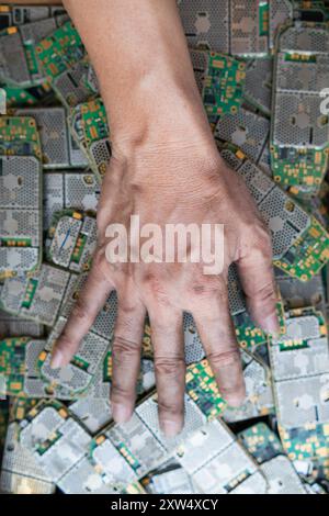 Ein Stapel Elektroschrott in der Fabrikhalle ist eine Leiterplatte des Mobiltelefons, die darauf wartet, verarbeitet zu werden, extrahiert Gold, um Edelmetall von Elektr zu trennen Stockfoto
