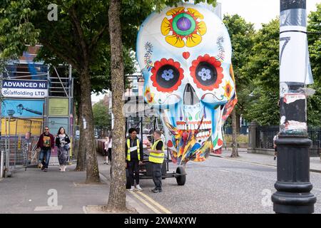 Belfast Mela Carnival Parade – riesiger farbenfroher Totenkopf Day of the Dead im mexikanischen Stil. Belfast, Großbritannien - 17. August 2024. Stockfoto