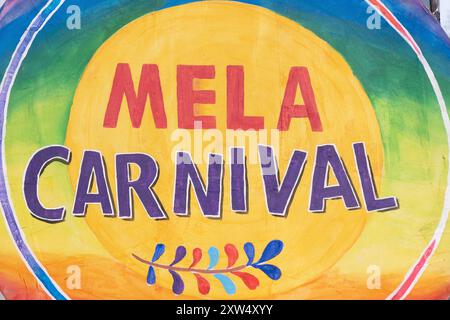 Belfast Mela Carnival Parade – hell gemaltes Logo auf der Seite der Fahrzeuganzeige in leuchtend gelb-grüner Schrift. Belfast, Großbritannien - 17. August 2024. Stockfoto