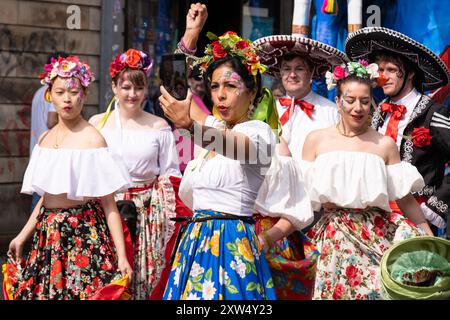 Belfast Mela Carnival Parade - wunderschöne Frauen in verschiedenen Kostümen, darunter Südamerika, die Farbe und Eleganz verleihen. Belfast, Großbritannien - 17. August 2024. Stockfoto