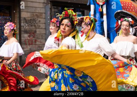 Belfast Mela Carnival Parade, eine Gruppe von Frauen in wunderschönen und raffinierten Kostümen, die im Stadtzentrum tanzen. Belfast, Großbritannien - 17. August 2024. Stockfoto