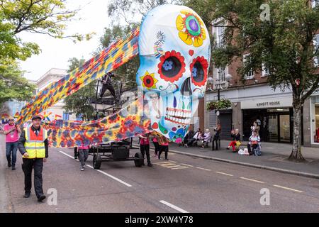 Jährliche Belfast Mela Carnival Parade - riesige bunte Day of the Dead mexikanische Schädelmuster vor dem Wagen im Stadtzentrum. Belfast, Großbritannien - 17. August 2024 Stockfoto