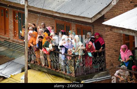 Srinagar, Indien. August 2024. Frauen duschen Toffees während der Poshak Bandi, einer Zeremonie, bei der das Tuch gewechselt wird, am 17. August 2024 im Pakherpora-Schrein, 48 Kilometer von Srinagar, Kaschmir, Indien, entfernt. Nach lokaler Tradition wurde Hazrat Sultan Sayed Muhammad Ali Balkhi als ein Nachfahre des Propheten Muhammad angesehen und regierte die Stadt Millahin Balkh, die im heutigen Afghanistan liegt. (Foto: Danish Showkat/SIPA USA.) Quelle: SIPA USA/Alamy Live News Stockfoto