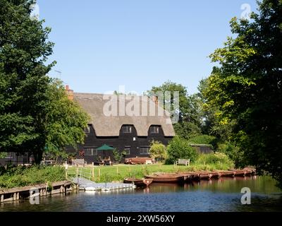 EAST BERGHOLT, SUFFOLK, Großbritannien - 29. JULI 2024: Blick auf den Teesaal Flatford Mill auf der anderen Seite des Flusses Stour Stockfoto