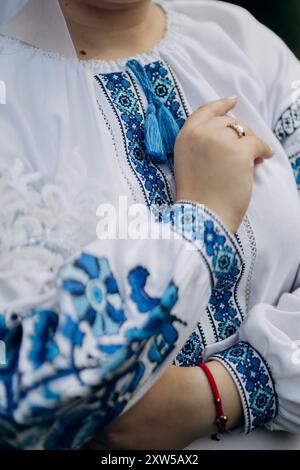 Nahaufnahme traditioneller ukrainischer Hochzeitskleidung mit aufwändiger blauer Stickerei, die das kulturelle Erbe symbolisiert Stockfoto