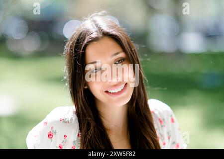 Close up Happy lächelnd schöne junge Latina Teenager Teenager weiblich sitzend Park Stockfoto