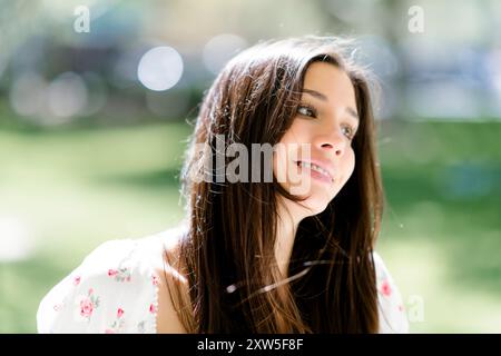 Close up Happy lächelnd schöne junge Latina Teenager Teenager weiblich sitzend Park Stockfoto