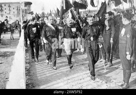 Der faschistische marsch auf Rom. 1922 veranstalteten die Faschisten unter der Leitung von Mussolini eine Massendemonstration in Form eines massenabzugs nach Rom. Es gab weniger als 30.000 Menschen auf dem marsch, aber König Viktor Emanuel II. Fürchtete einen Bürgerkrieg und dankte ab und übergab Mussolini die Macht. Dieses Bild zeigt Emilio de Bono (Far L, neben dem Geländer), Benito Mussolini, Cesare Maria de Vecchi (helle Hosen und Medaillen) und Michele Bianchi (R, tragendes Schwert) auf dem marsch. Stockfoto