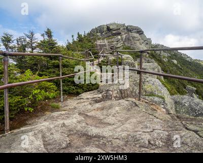 Eine zerklüftete Reise entlang des gewundenen, felsigen Pfades mit eisernen Geländern, die zum Gipfelhaus auf dem Whiteface Mountain führt, von dem aus Sie eine atemberaubende Aussicht auf den Berg genießen können Stockfoto