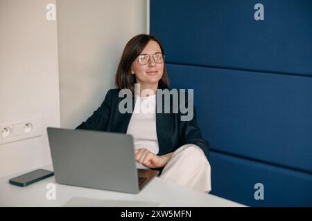 Eine Geschäftsfrau in einem modernen Büro konzentriert sich auf die Arbeit mit Notebooks und zeigt Vertrauen Stockfoto