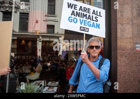 London, Großbritannien. August 2024. Der Demonstrant hält während der Demonstration ein Plakat vor dem Angus Steakhouse. Hunderte Aktivisten versammelten sich zum National Animal Rights March in London, Großbritannien. Tierschutzorganisationen organisierten einen Protest, um die Tierbefreiung zu fordern. Demonstranten marschierten vom Marmorbogen zum Parlamentsplatz. (Foto: Krisztian Elek/SOPA Images/SIPA USA) Credit: SIPA USA/Alamy Live News Stockfoto