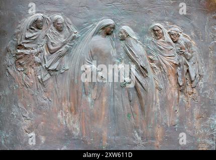 MAILAND, ITALIEN - 7. MÄRZ 2024: Das moderne brozne-Relief der Visitation am Tor der Kirche Chiesa di Santa Maria del Suffragio Stockfoto