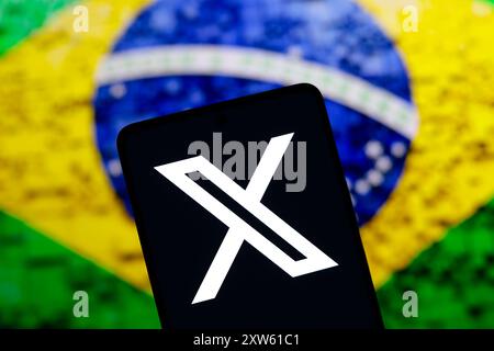 Paraguay. August 2024. In dieser Fotoabbildung wird das X (Twitter)-Logo auf einem Smartphone-Bildschirm mit einer Flagge von Brasilien im Hintergrund angezeigt. Das soziale Netzwerk X gibt bekannt, dass es sein Büro in Brasilien schließen wird Credit: SOPA Images Limited/Alamy Live News Stockfoto