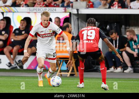Leverkusen, Deutschland. August 2024. Nathan Tella (R) von Bayer 04 Leverkusen streitet mit Chris Fuehrich vom VfB Stuttgart beim Finale des deutschen Supercups 2024 zwischen Bayer 04 Leverkusen und VfB Stuttgart am 17. August 2024 in Leverkusen. Quelle: Joachim Bywaletz/Xinhua/Alamy Live News Stockfoto