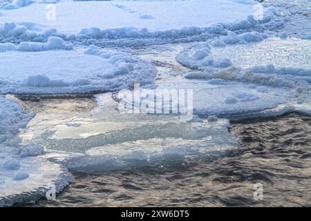 Ein paar Auswaschungen zwischen den gefrorenen runden Eisschollen (Pfannkucheneis) am nördlichen Fluss an einem frostigen Morgen Stockfoto