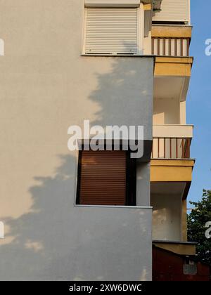 Zwei geschlossene Fensterrahmen in weiß und Braun: Morning Shadows on the Wall, Terrace – Residential Architecture. Stockfoto