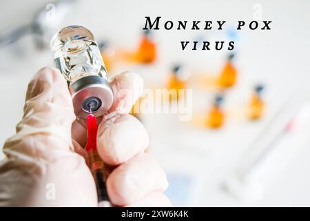 Mpox neuer Impfstoff in Ampullen und Flaschen, Nadel und Arzthänden mit Handschuh. Stockfoto