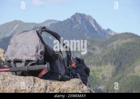 Wanderausrüstung aus Tasche und Stangen auf dem Hintergrund der Berge mit blauem Himmel Stockfoto