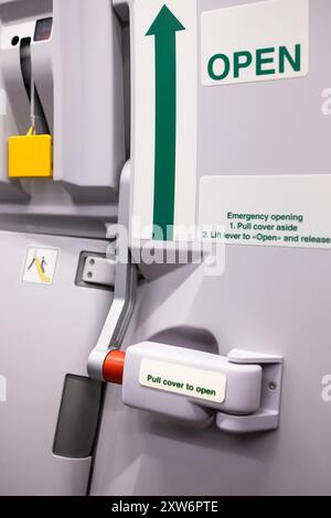 Eine Nottür in der Flugzeugkabine. Geschlossene Eingangstür für Passagierflugzeuge, Innenansicht mit aufblasbarer Evakuierungsrutsche in bewaffneter Stellung Stockfoto
