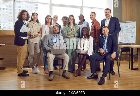 Gruppe selbstbewusster Geschäftsleute, die im Büro stehen und lächeln. Stockfoto
