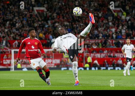 Fulham-Mittelfeldspieler Alex Iwobi (17) überspielte Manchester United-Mittelfeldspieler Amad Diallo (16) während des Spiels Manchester United FC gegen Fulham FC English Premier League in Old Trafford, Manchester, England, Großbritannien am 16. August 2024 Credit: Every Second Media/Alamy Live News Stockfoto