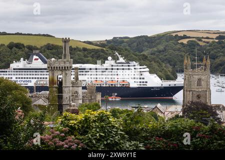 Fowey, Großbritannien. 17. August Das Kreuzfahrtschiff Vasco de Gama dominiert die kleine kornische Küstenstadt Fowey, Cornwall, Großbritannien. Das 58.000 Tonnen schwere Kreuzfahrtschiff wird von der deutschen Kreuzfahrtlinie Nick Cruises betrieben und hat 1000 Passagiere, wodurch sich die winzige 2.315-köpfige Gemeinde fast verdoppelt hat! Letztes Jahr gab es Aufruhr von der lokalen Bevölkerung, als The Spirit of Adventure in die Stadt kam und die Aussicht auf die malerische Stadt vernichtete. Quelle: Mark Passmore/ Alamy Live News Stockfoto