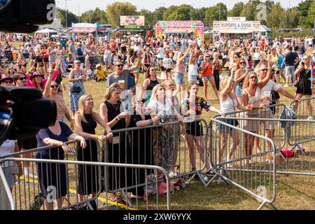 Essex, Großbritannien. August 2024. Publikum-Atmosphäre beim Festivaljubel. Das Big 90s vs 00s Festival, auf dem Waterside Farm Recreation Ground, Canvey Island. Die Band Let Loose und Luzahnn Taylor aka Livin Joy gingen auf die Bühne und ließen die Leute tanzen und mitjubeln. Let Loose Current Line-up sind die ursprünglichen Mitglieder Lee Murray und Rob Jeffrey und sie werden von dem Leadsänger einer weiteren beliebten 90er-Band Bad Boys Inc. Matthew James Pateman begleitet. Quelle: SOPA Images Limited/Alamy Live News Stockfoto