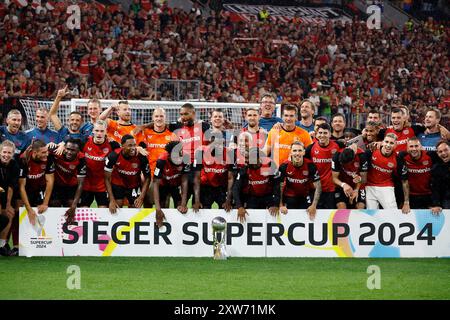 Leverkusen, Deutschland 1. Fussball Bundesliga, Supercup 2024 Bayer 04 Leverkusen : VFB Stuttgart 4:3 N.E. 17. 08. 2024 in der Bay-Arena in Leverkusen präsentiert die Leverkusener Mannschaft den Supercup hinter dem Winnerboard Foto: Norbert Schmidt, Düsseldorf Stockfoto