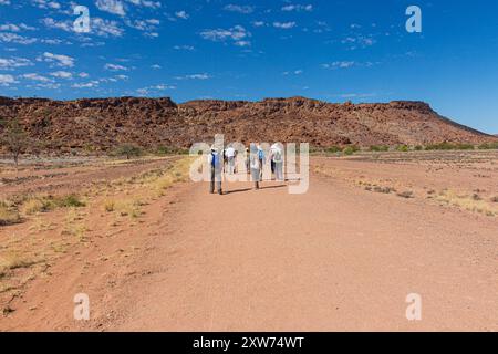 Touristen auf dem Weg zu den antiken Felsmalereien in der Twyfelfontein Landschaft, Namibia, Afrika Stockfoto