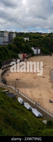 Vertikale Panoramaaufnahme des Nordstrandes in Tenby gegenüber dem Hafeneingang. Der Sand ist Golden und es gibt Touristen, die die Sonne genießen Stockfoto