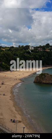 Vertikale Panoramaaufnahme des Nordstrandes in Tenby gegenüber dem Hafeneingang. Der Sand ist Golden und es gibt Touristen, die die Sonne genießen Stockfoto