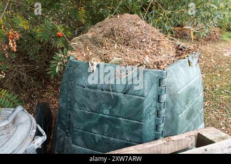 Plastikbehälter - Komposter im Garten, gefüllt mit geschnittenem Gras Stockfoto