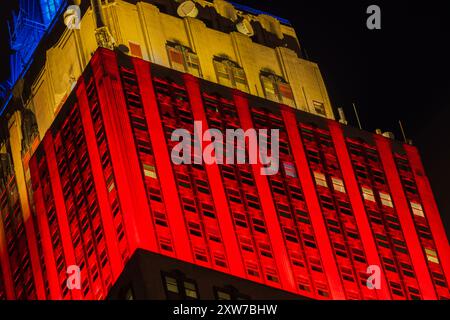 Nächtliche Nahaufnahme des Empire State Building mit roten, gelben und blauen Lichtern in den oberen Stockwerken. New York. USA. Stockfoto