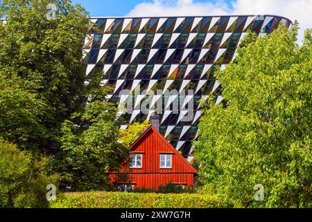 Traditionelles schwedisches rotes Blockhaus vor der Aula Medica, Karolinska Institutet in Solna, Stockholm. Das Auditorium ist ein Gebäude für Karolinska Inst Stockfoto