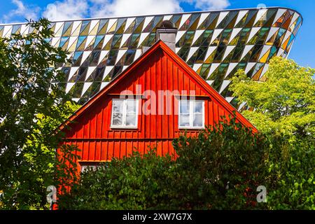 Traditionelles schwedisches rotes Blockhaus vor der Aula Medica, Karolinska Institutet in Solna, Stockholm. Das Auditorium ist ein Gebäude für Karolinska Inst Stockfoto