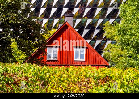 Traditionelles schwedisches rotes Blockhaus vor der Aula Medica, Karolinska Institutet in Solna, Stockholm. Das Auditorium ist ein Gebäude für Karolinska Inst Stockfoto