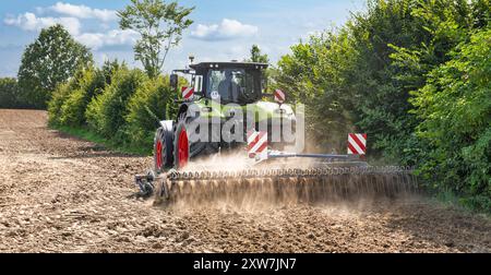 Traktor mit Kultivator, der nach der Getreideernte am Feldrand arbeitet - 2045 Stockfoto