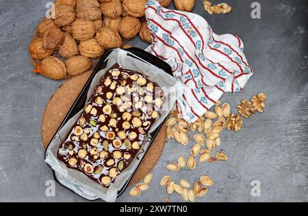 Schokoladenkuchen mit Pistazien und Nüssen in einem Backblech Stockfoto