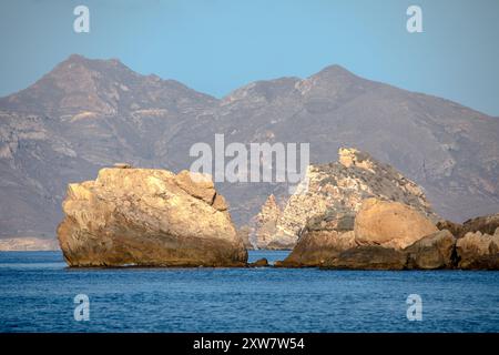 Blick auf die Klippen an der Küste von Cartagena, Region Murcia, Spanien, im frühen Morgenlicht und mit kleinen Felsen und Inseln im Meer Stockfoto