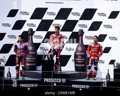 Die drei Fahrer auf dem Podium während der italienischen Nationalhymne nach dem Rennen des MotoGP Motorrad Grand Prix von Osterreich 2024, RedBull Ring Circuit, Spielberg, Österreich.18. August 2024 (Foto: Daniele Marangoni/SIPA USA) Stockfoto